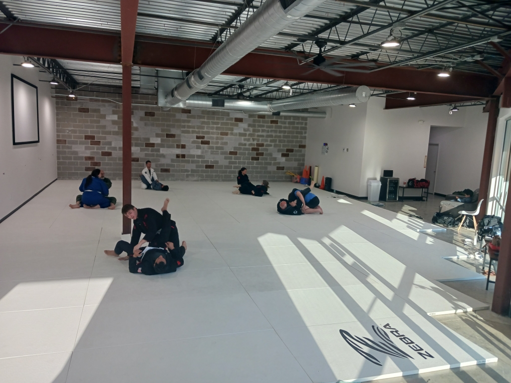 Students practicing Brazilian Jiu-Jitsu at the academy